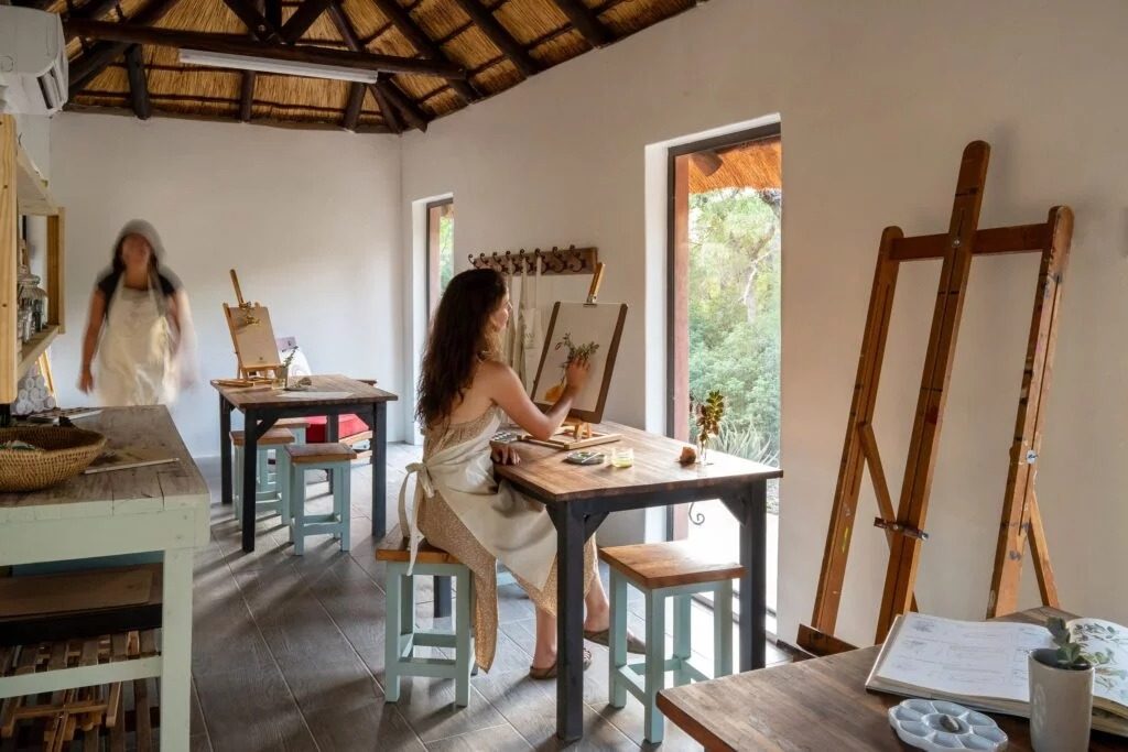 A guest painting botanical studies in the art studio at Sashwa River of Stars